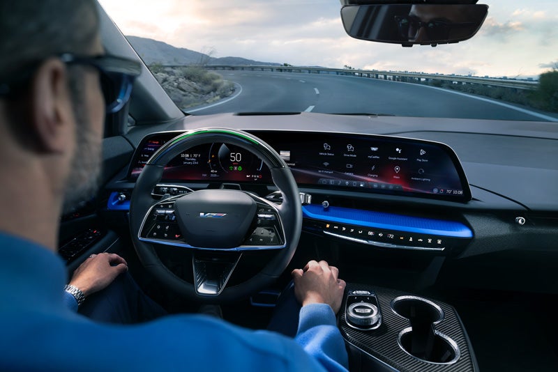 Front View of the 2026 OPTIQ-V Driving Through the Dusk Utilizing its Headlights | Lima Cadillac in LIMA OH